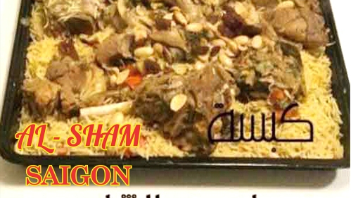 Mâm cơm kabsa — cơm gia vị, thịt, hạt và nho khô