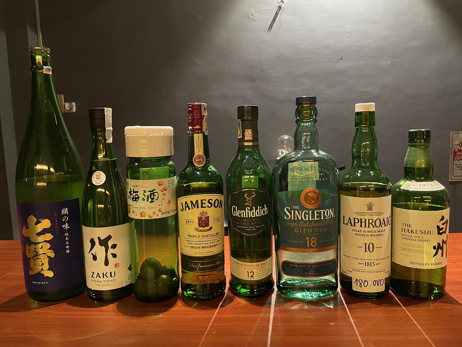 Chinh, Bar Mitsuboshi's owner, behind the counter in front of the bar's bottle lineup