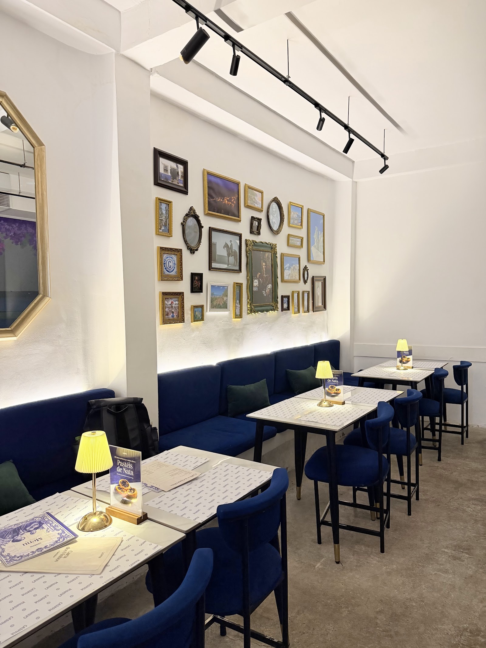 The dining room — blue banquettes, gallery wall of framed art