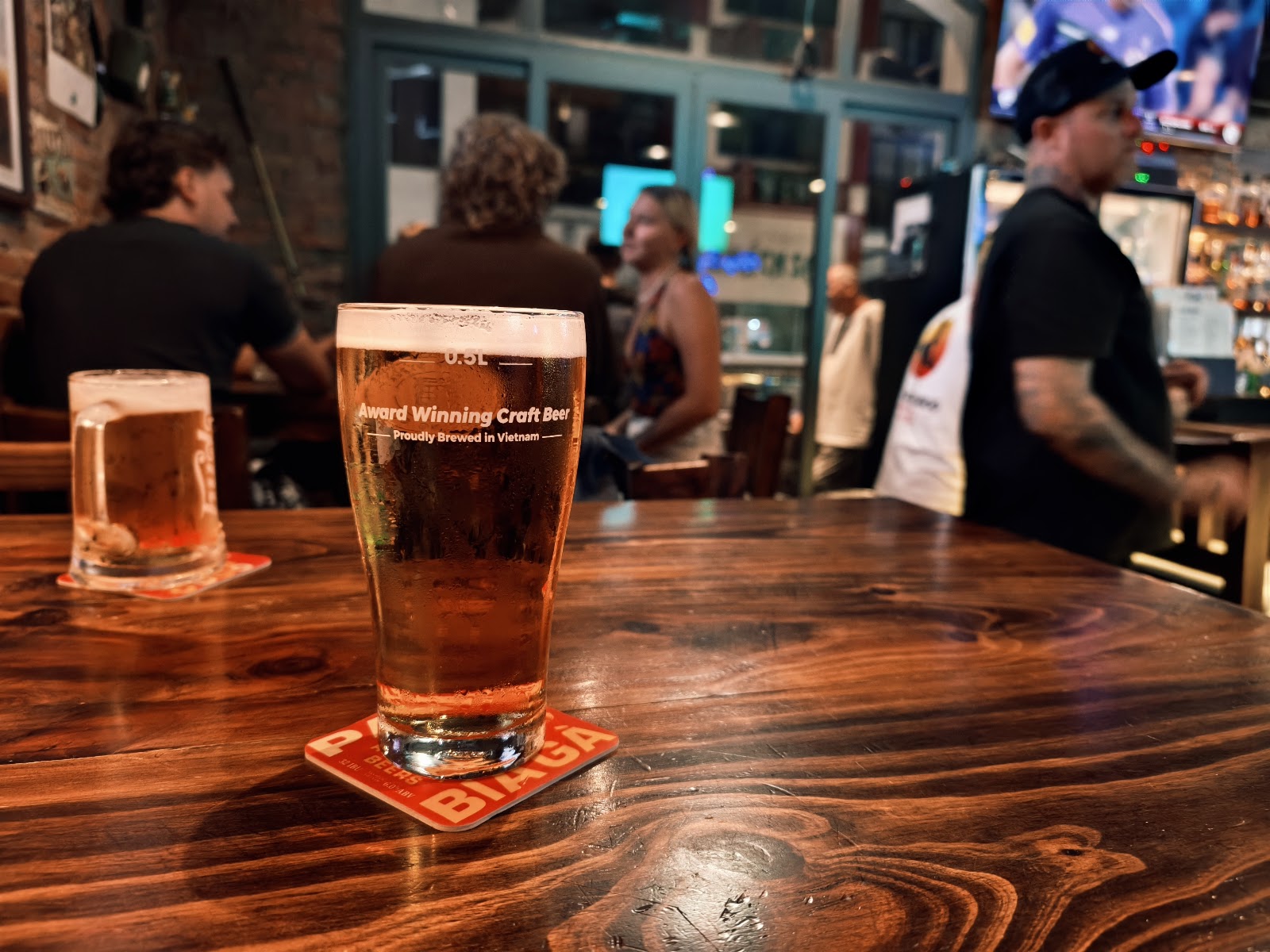 Rót bia thủ công tại quầy bar, khách quen xung quanh