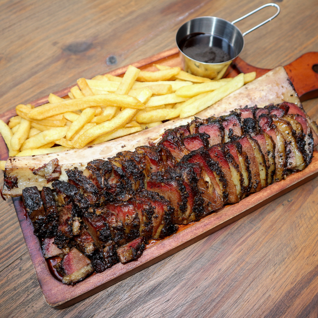 Smoked brisket platter with fries and a sauce jug