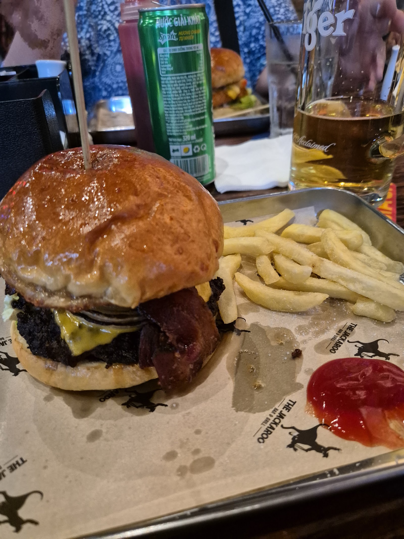 Bacon cheeseburger with fries and a Tiger beer