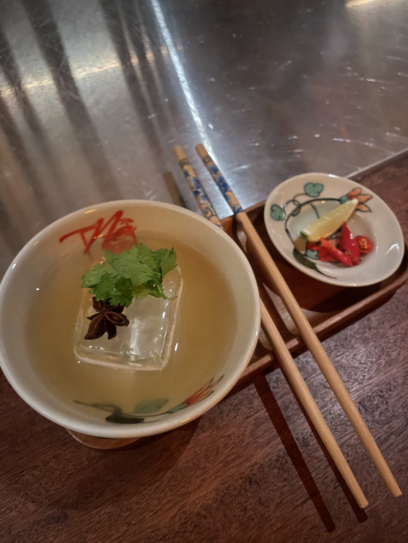 Nê's phở cocktail served in a bowl, with chopsticks
