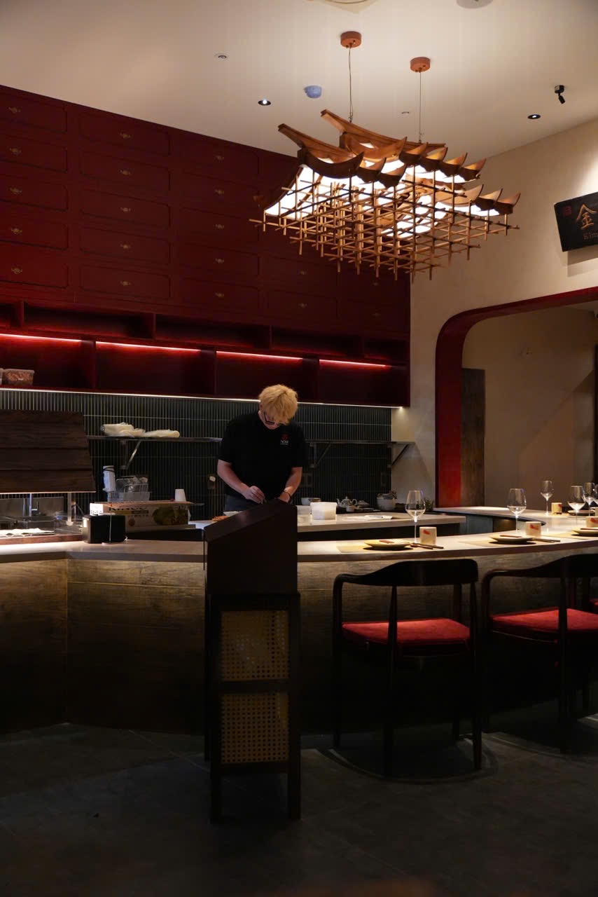 NOM's chef counter beneath the pagoda-roof chandelier