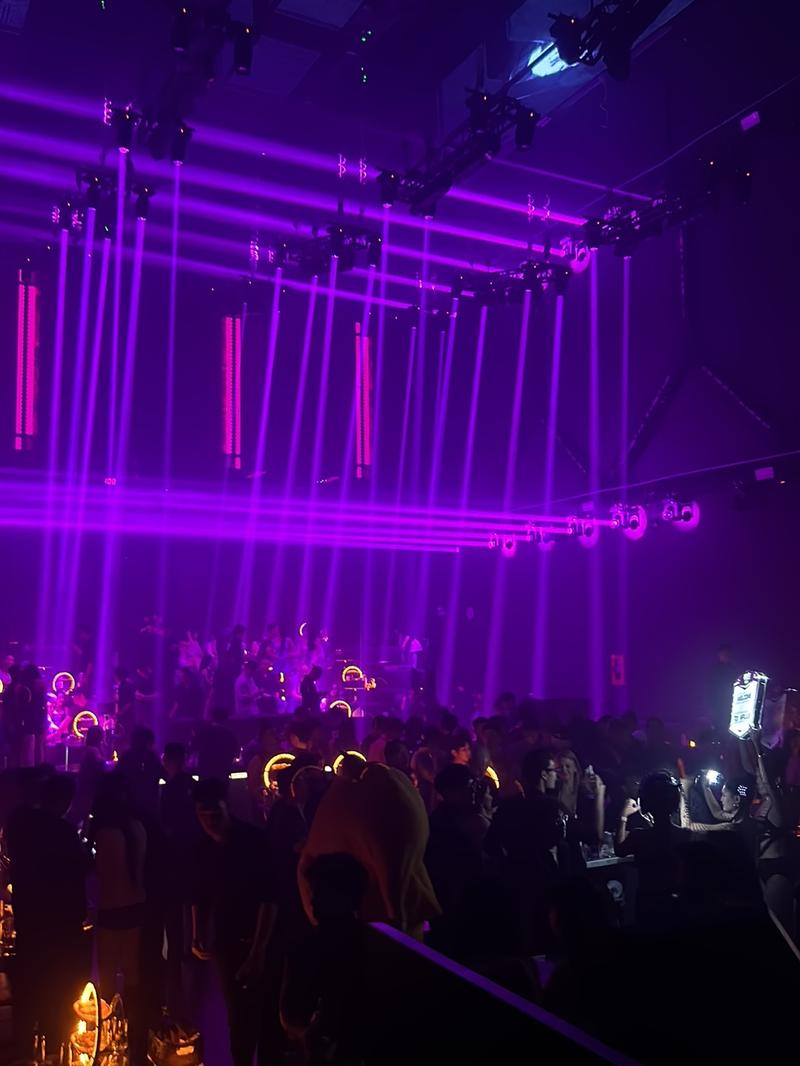 A packed crowd at APLUS Saigon under the violet rig
