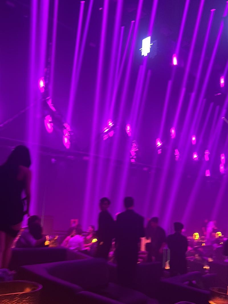 Guests standing in the violet haze at APLUS Saigon