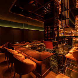 Whiskey Lane's bar counter with leather seats and glowing shelves