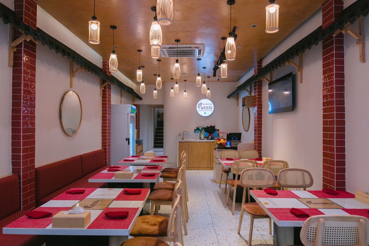 The long dining hall — bamboo pendants, red banquette, backlit logo