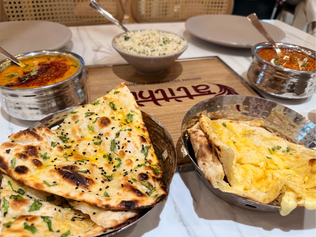 Garlic and cheese naan in steel baskets with curries
