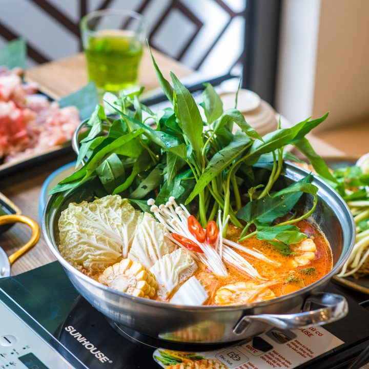 Thai-style hot pot — morning glory, napa cabbage, enoki, corn, chili in orange broth