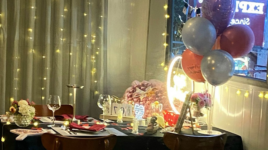 밤의 축하 테이블 — 와인잔, 풍선, 전구 조명, 빛나는 링 조명