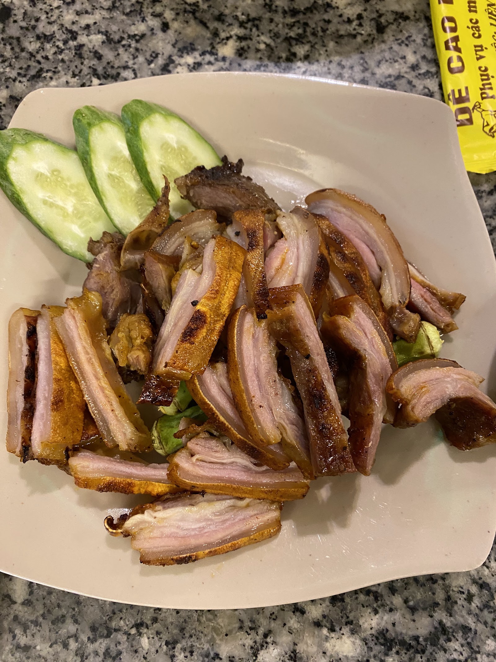 Grilled and roasted goat, sliced, with cucumber