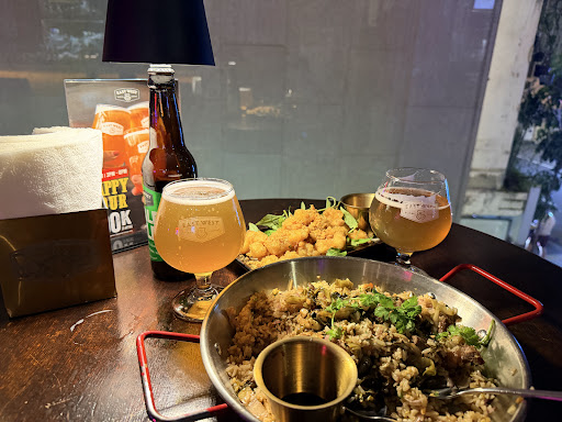 맥주 두 잔, 볶음밥, 바삭한 치킨이 있는 테이블