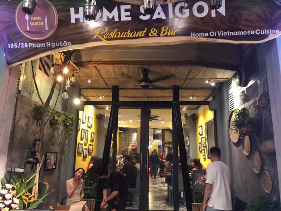 밤의 곡선 나무 HOME SAIGON 간판 — 팜응우라오 185/28