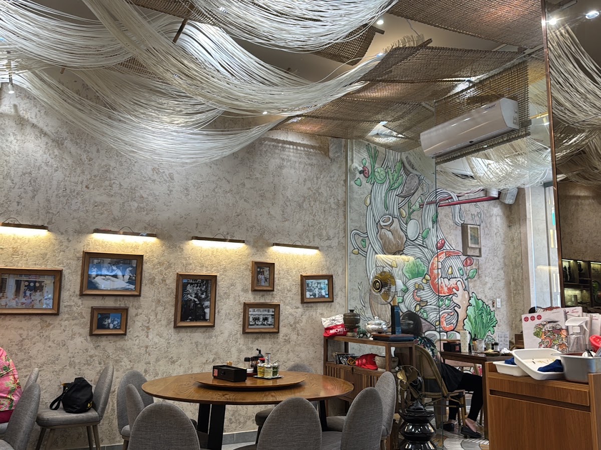 Noodle-strand ceiling drapery, framed vintage photos, warm sconces, service counter