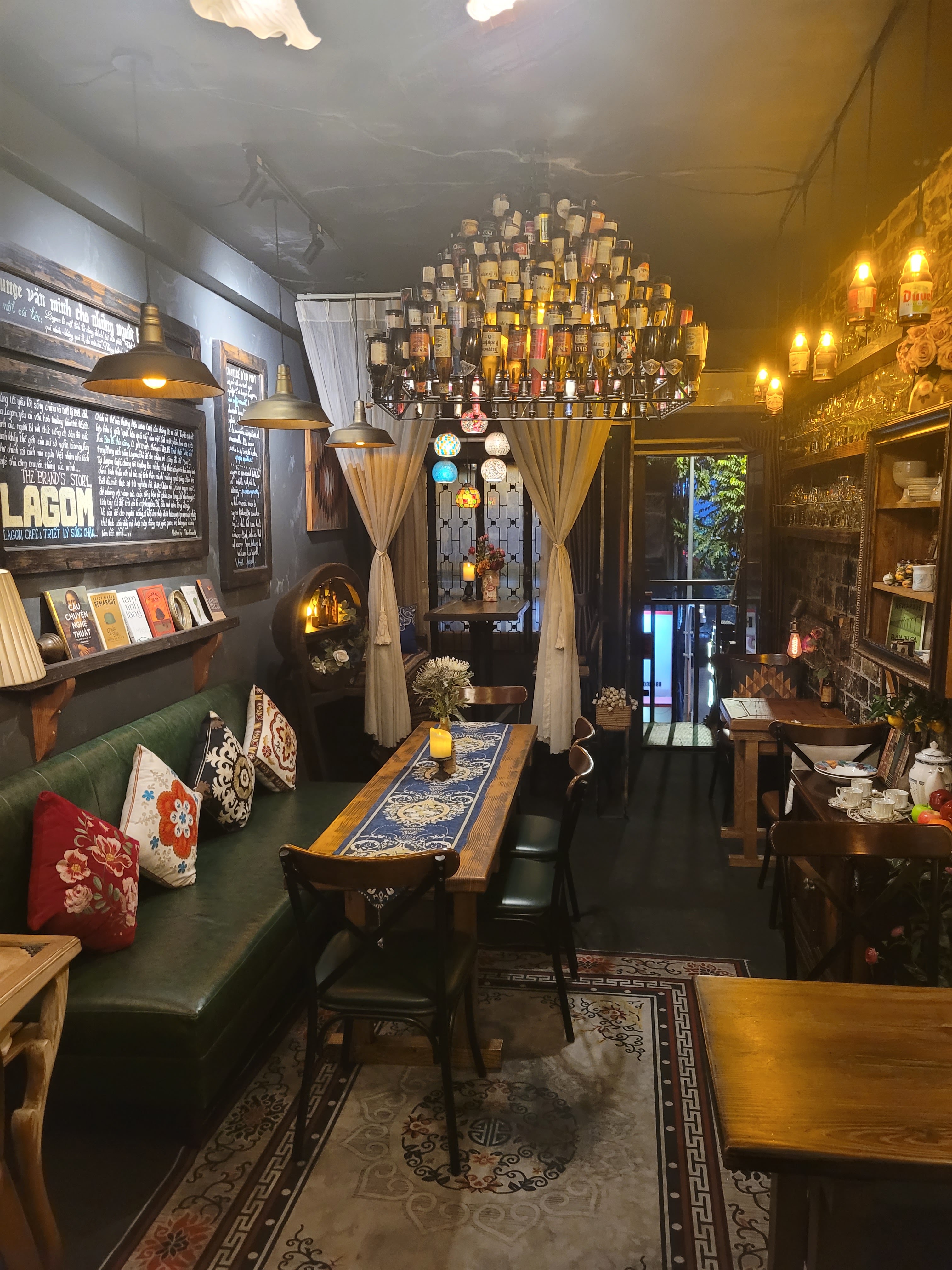 Green banquette corner, bottle chandelier, LAGOM chalkboard