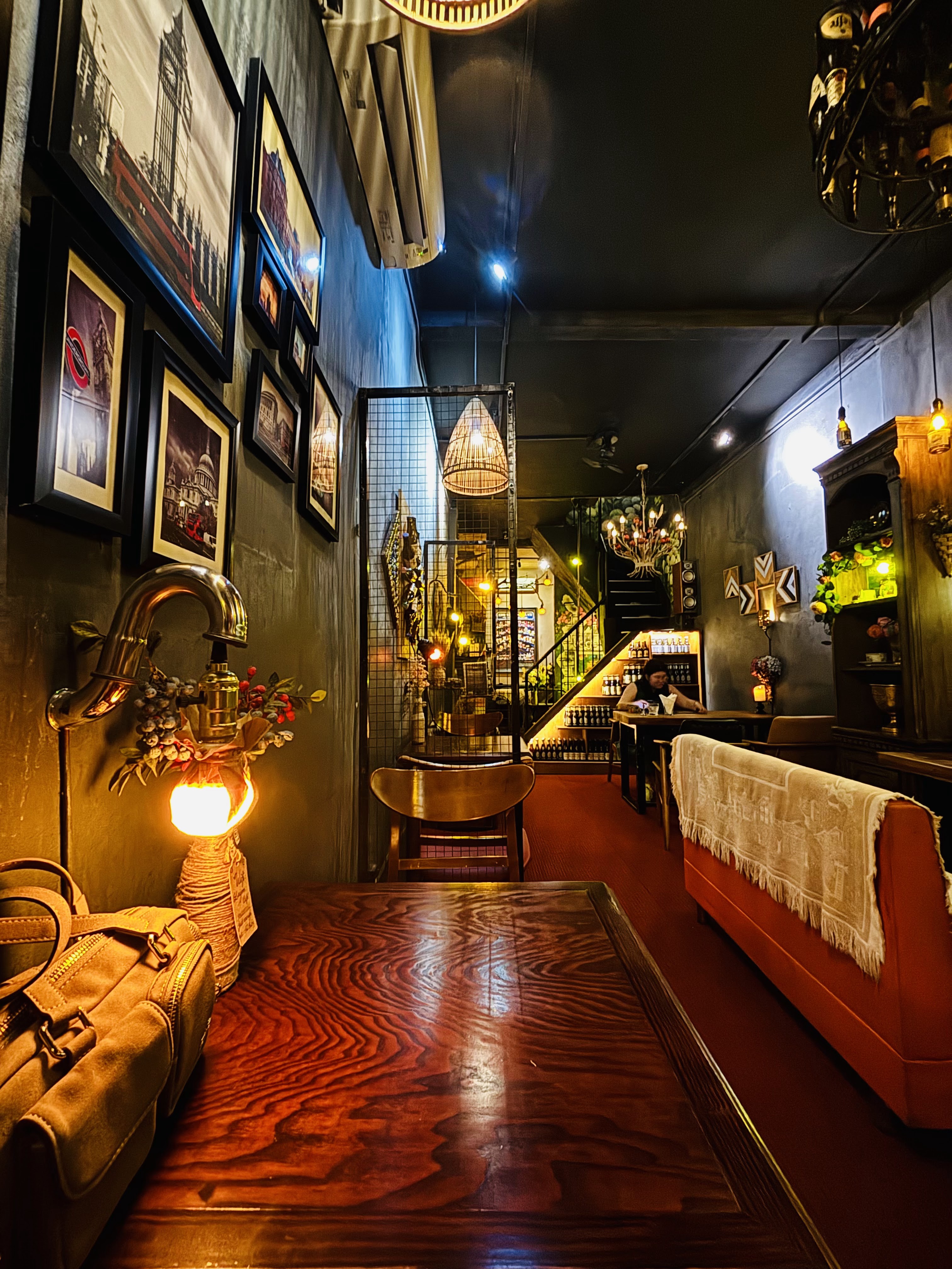 Gallery-wall corridor, woven lamps, red banquette
