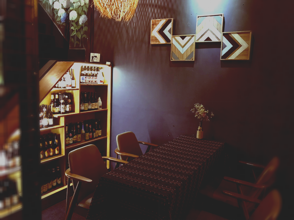 Backlit bottle shelving under staircase, chevron wall art