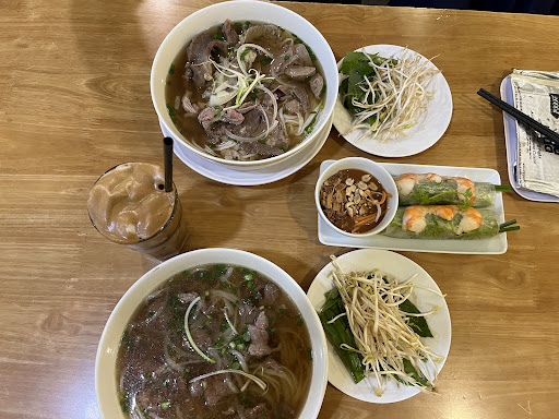 Two beef phở bowls, shrimp spring rolls, cà phê sữa đá