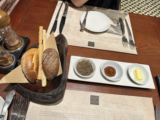 무료 빵 서비스 — 어두운 목재 테이블 위 세 가지 스프레드와 롤, 브레드스틱 바구니