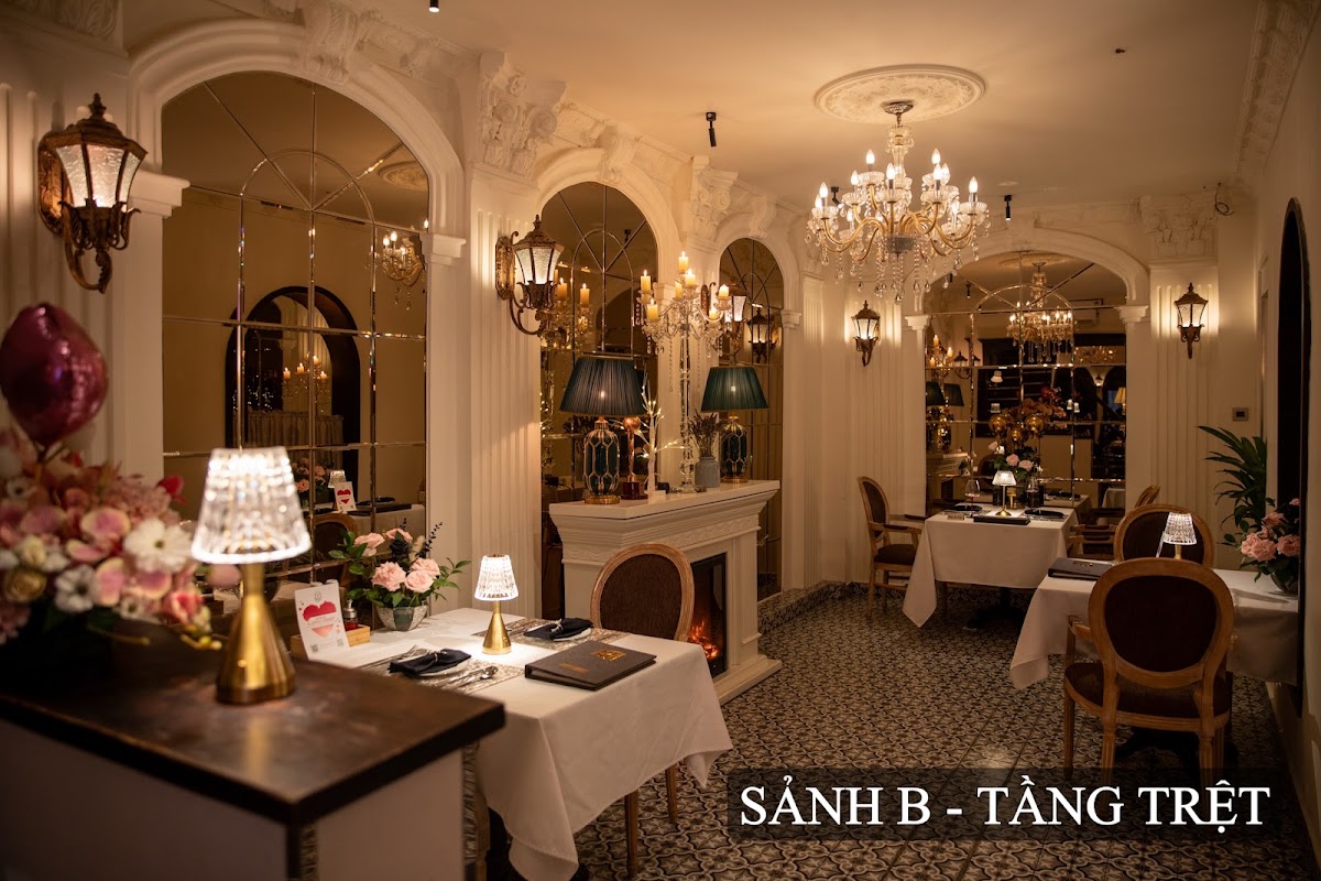 Hall B on the ground floor — chandeliers, arched mirrors, fireplace, white-clothed tables