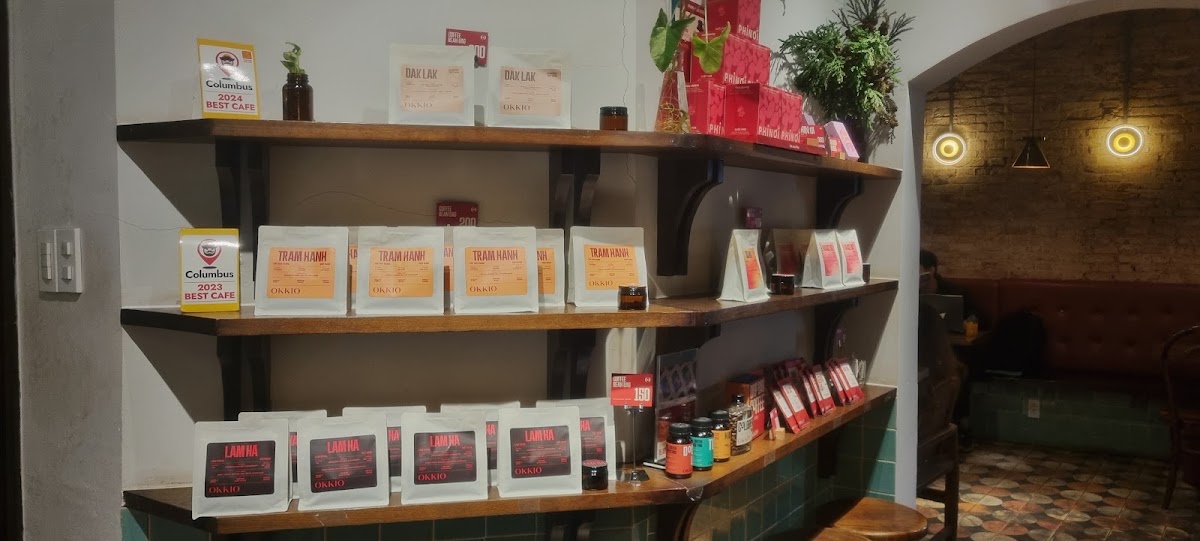 리테일 코너 — 싱글 오리진 백, BEST CAFE 스티커, 아치를 통해 보이는 가죽 벤치
