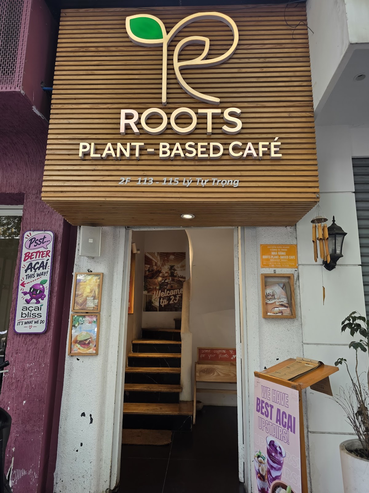 외관 — 나무 ROOTS 간판, 2층으로 오르는 계단, 인도 아사이 보드