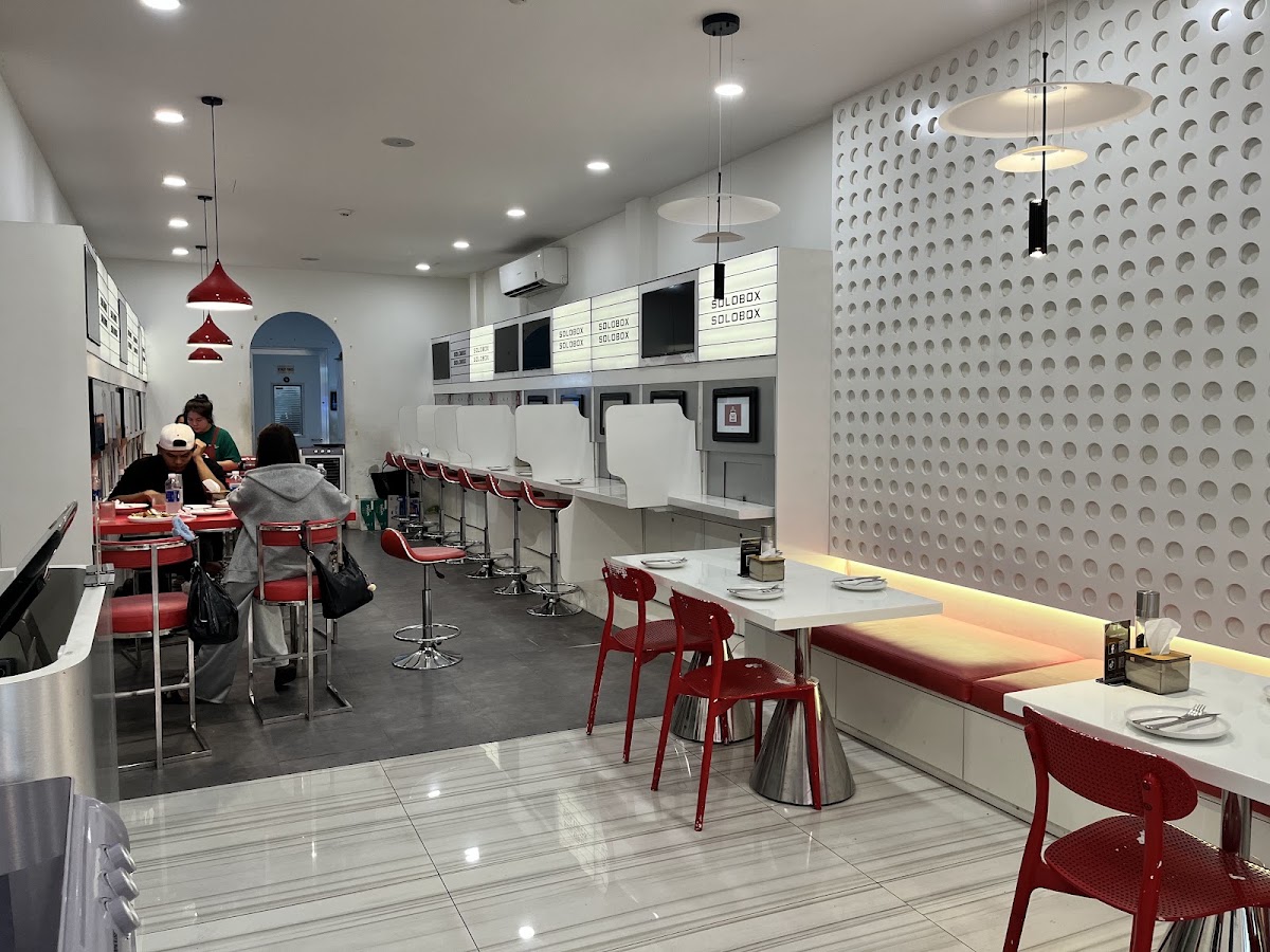 Dining room — white perforated block wall, booth counter, red tables
