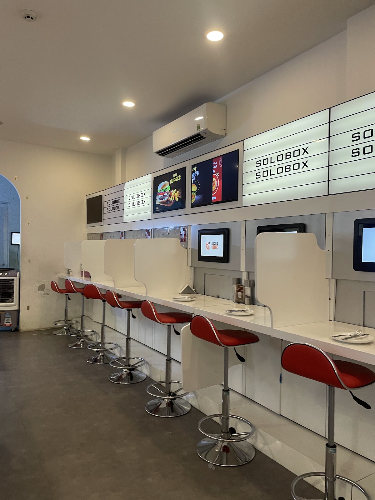 Empty solo-dining counter row with privacy dividers